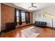 Spacious living room features exposed brick wall, hardwood floors, and modern ceiling fan at 1475 N Humboldt St # 20, Denver, CO 80218