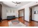 Spacious living room with hardwood floors, dark trim, black futon couch, ceiling fan, and view to next room at 1475 N Humboldt St # 20, Denver, CO 80218
