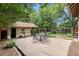 Charming backyard patio with stone flooring, a brick building, and mature trees, perfect for outdoor entertaining at 4010 Grove St, Denver, CO 80211