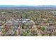 An aerial view of a residential neighborhood with a mix of homes, mature trees, and distant mountain scenery at 1027 S University Blvd, Denver, CO 80209