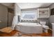 Relaxing bathroom featuring a large soaking tub, shower, and ample natural light from the window at 1027 S University Blvd, Denver, CO 80209