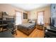 Comfortable bedroom featuring hardwood floors, a large window, and ample natural light at 1027 S University Blvd, Denver, CO 80209