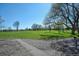 Scenic view of green space with lush grass, large mature trees, and walking path under a clear sky at 1027 S University Blvd, Denver, CO 80209
