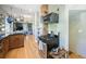 Cozy kitchen showcases wooden cabinets, a gas range, and an open layout to the living area at 1027 S University Blvd, Denver, CO 80209
