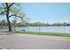 A scenic view of a lake, showing a serene spot with a bench and lush trees under a clear blue sky at 1027 S University Blvd, Denver, CO 80209