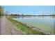 Picturesque view of a serene lake with grassy banks and a walking path under a clear blue sky at 1027 S University Blvd, Denver, CO 80209
