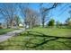 Scenic view of a park with lush green grass, a walking path, and mature trees under a sunny sky at 1027 S University Blvd, Denver, CO 80209