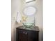 Stylish powder room with a glass bowl sink, modern faucet, and oval decorative mirror at 3249 W Fairview Pl # 106, Denver, CO 80211