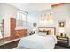 Bright bedroom with exposed brick wall, large windows, and modern lighting fixtures at 3249 W Fairview Pl # 106, Denver, CO 80211