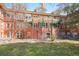 Charming red brick building featuring a unique covered patio and a well-manicured green lawn area at 3249 W Fairview Pl # 106, Denver, CO 80211