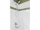 Clean shower with white tiled walls, green accent stripe, and modern shower head at 3249 W Fairview Pl # 106, Denver, CO 80211
