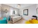 This bedroom boasts a floral daybed, a yellow chair, and lots of natural light from the large window at 4523 Crestone Peak St, Brighton, CO 80601