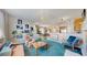 Bright open-concept living room featuring a plush teal carpet, plants, and comfortable furnishings at 4523 Crestone Peak St, Brighton, CO 80601