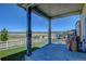 Covered porch with stone pillars and well-maintained artificial grass and backyard at 5837 High Timber Cir, Castle Rock, CO 80104