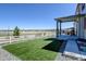 Artificial turf backyard with covered patio and open views, ideal for outdoor living and entertaining at 5837 High Timber Cir, Castle Rock, CO 80104