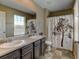 Bathroom featuring a double vanity with dark wood cabinets, a large mirror, and a shower with curtain at 5837 High Timber Cir, Castle Rock, CO 80104