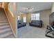 Bright and spacious living room with staircase access, offering a comfortable and inviting atmosphere for Gathering and guests at 5837 High Timber Cir, Castle Rock, CO 80104