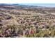 High angle aerial view of homes surrounded by lush forests near the highway in the mountains at 23626 Genesee Village Rd, Golden, CO 80401