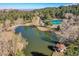 Aerial view of community pond, tennis courts, lush landscaping, and mountainous scenery at 23626 Genesee Village Rd, Golden, CO 80401