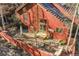 Red-painted home featuring a wooden patio, outdoor seating, and trees in the fenced backyard at 23626 Genesee Village Rd, Golden, CO 80401