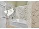 Modern bathroom with white marble-style tiling, featuring a soaking tub and shower combination at 23626 Genesee Village Rd, Golden, CO 80401