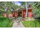 Charming red home with a landscaped front yard and a stone pathway leading to the inviting front door at 23626 Genesee Village Rd, Golden, CO 80401