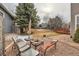 Relaxing backyard featuring stone fire pit area, patio with lounge seating, and expansive lawn at 240 Corby Pl, Castle Pines, CO 80108