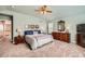 Bedroom featuring neutral colors, ceiling fan, plantation shutters, and ensuite at 240 Corby Pl, Castle Pines, CO 80108