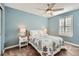 Comfortable bedroom with a ceiling fan and a large window with white shutters at 240 Corby Pl, Castle Pines, CO 80108