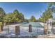 Community pool surrounded by trees, fence, and brick columns at 240 Corby Pl, Castle Pines, CO 80108