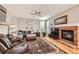 Cozy living room with a brick fireplace, hardwood floors, and comfortable seating at 240 Corby Pl, Castle Pines, CO 80108