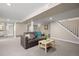 Finished basement area with new carpet, neutral walls and a comfortable gray couch at 991 E Applewood Ave, Centennial, CO 80121