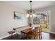 Sunlit dining room features an industrial-style light fixture and a long wooden table with seating at 991 E Applewood Ave, Centennial, CO 80121