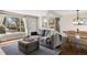 Cozy living room featuring stylish gray sofa, ottoman, and seamlessly connected to the dining area at 991 E Applewood Ave, Centennial, CO 80121