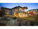 Beautifully landscaped backyard with stone accents, covered patio, and manicured lawn at 703 Emberglow Ln, Highlands Ranch, CO 80126
