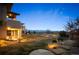 Expansive backyard features lush landscaping, a covered patio, and panoramic views at 703 Emberglow Ln, Highlands Ranch, CO 80126