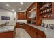 Custom bar area with a sink, microwave, marble countertop, cabinetry, and display shelves at 703 Emberglow Ln, Highlands Ranch, CO 80126