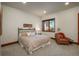 Calm bedroom featuring a cozy queen size bed, a chair, and a window with natural light at 703 Emberglow Ln, Highlands Ranch, CO 80126