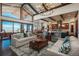 Bright living room with vaulted ceilings, exposed beams, and expansive windows with stunning views at 703 Emberglow Ln, Highlands Ranch, CO 80126