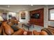 Elegant living room featuring a stone accent wall, TV, staircase and comfortable leather sofas at 703 Emberglow Ln, Highlands Ranch, CO 80126
