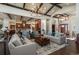 Open-concept living space with exposed beams, a view of the gourmet kitchen, and beautiful hardwood floors at 703 Emberglow Ln, Highlands Ranch, CO 80126