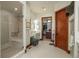 Main bathroom with glass shower, dual sinks, access to closet, and beautiful wood door trim at 703 Emberglow Ln, Highlands Ranch, CO 80126