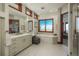 Bright bathroom featuring dual sinks, a makeup counter, soaking tub and large windows with great views at 703 Emberglow Ln, Highlands Ranch, CO 80126