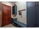Inviting mud room with wood door, storage shelves, seating bench, and convenient hooks at 703 Emberglow Ln, Highlands Ranch, CO 80126