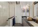 Modern bathroom with a tiled shower, double sinks, granite countertops, and brushed gold accents at 1242 Yates St # U2, Denver, CO 80204