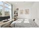 Stylish bedroom featuring a large window, modern decor, and a comfortable bed with patterned bedding at 1242 Yates St # U2, Denver, CO 80204
