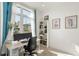 Bright home office features large window with neighborhood view, desk, and bookshelf at 1242 Yates St # U2, Denver, CO 80204