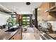 Stylish kitchen with modern appliances, wood cabinets, and a view of the living area through a glass garage door at 1242 Yates St # U2, Denver, CO 80204