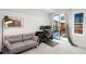 Cozy living room with ample natural light, modern gray couch, desk, and access to outdoor space at 1242 Yates St # U2, Denver, CO 80204