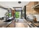 Stylish kitchen with modern appliances, wood cabinets, and a view of the living area through a glass garage door at 1242 Yates St # U2, Denver, CO 80204